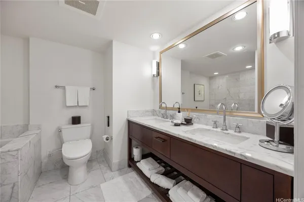 a bathroom with a double vanity sink toilet and mirror