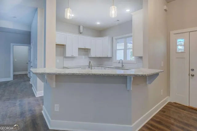 a kitchen with kitchen island granite countertop a sink and cabinets