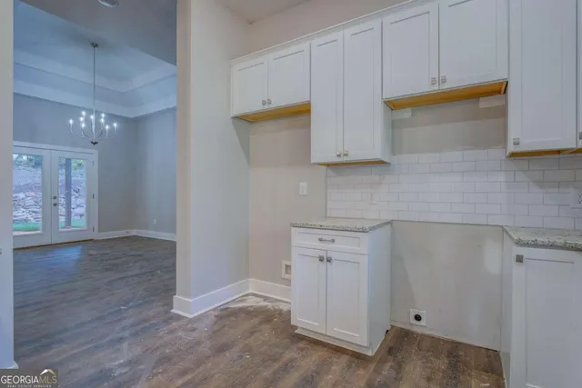 a kitchen with cabinets and wooden floor
