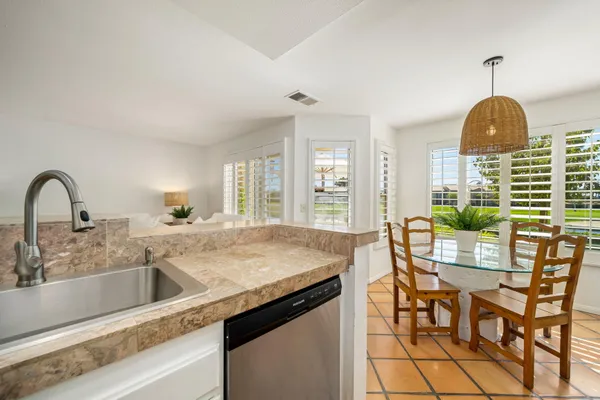 a kitchen with a dining table chairs and granite counter tops