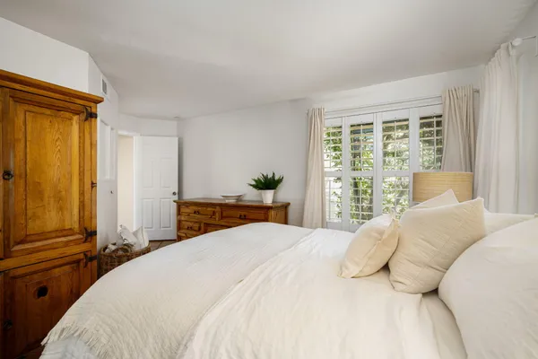 a bedroom with a bed and large windows