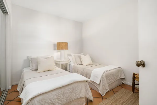 a bedroom with two beds and wooden floor