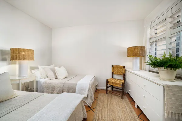 a living room with a bed furniture and a potted plant