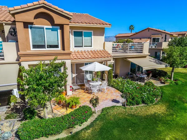 a view of a house with a yard and potted plants