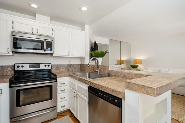 a kitchen with stainless steel appliances granite countertop a stove microwave and sink