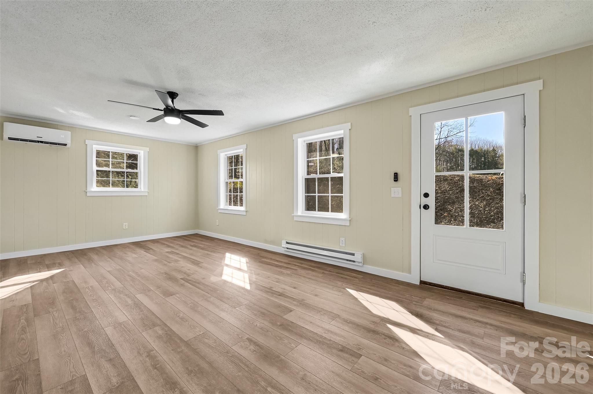 241 Sherrill Lane Canton, NC 28716 - Photo 16 of 39 a view of an empty room with a window and wooden floor