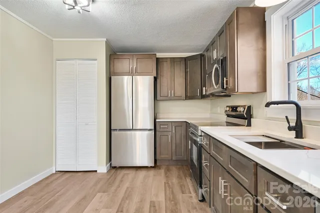 a kitchen with a refrigerator sink and cabinets