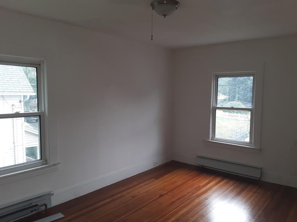 23 Bevier Street Springfield, MA 01107 - Photo 5 of 12 an empty room with wooden floor and windows