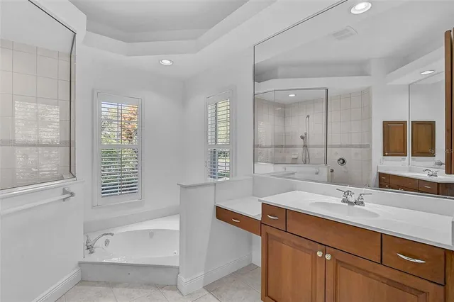 a bathroom with a sink tub double vanity and mirror