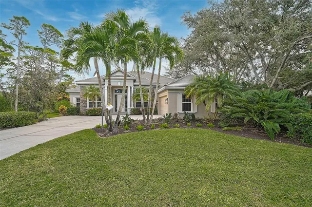 a view of a house with a yard and palm trees