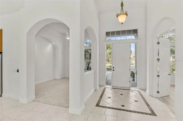 a view of a hallway with wooden floor and chandelier