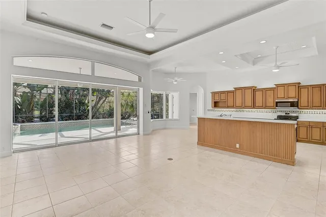 a large kitchen with stainless steel appliances granite countertop a large window and a counter top space