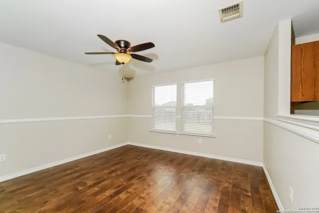 an empty room with a window and a ceiling fan