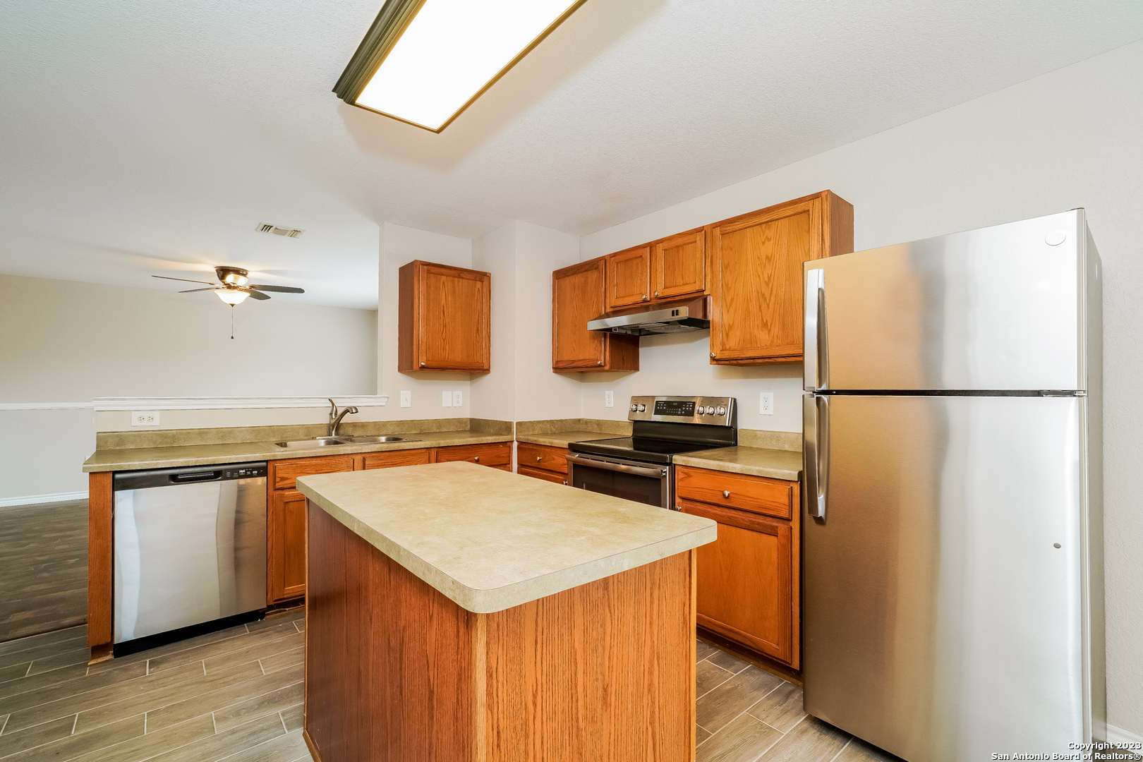 9620 Copper Sands Converse, TX 78109 - Photo 6 of 17 a kitchen with stainless steel appliances a sink and a refrigerator