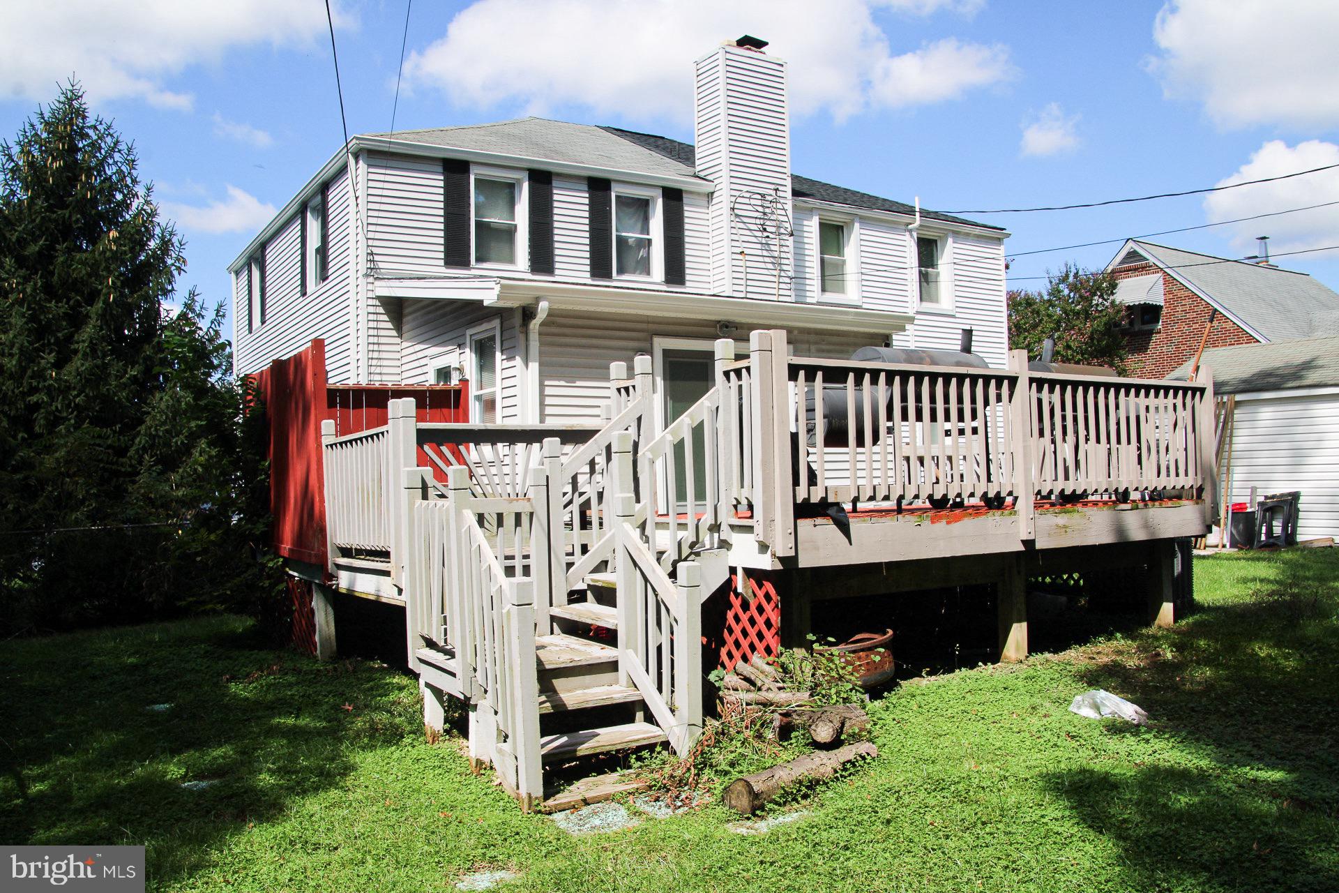 a front view of a house with a yard with potted plants