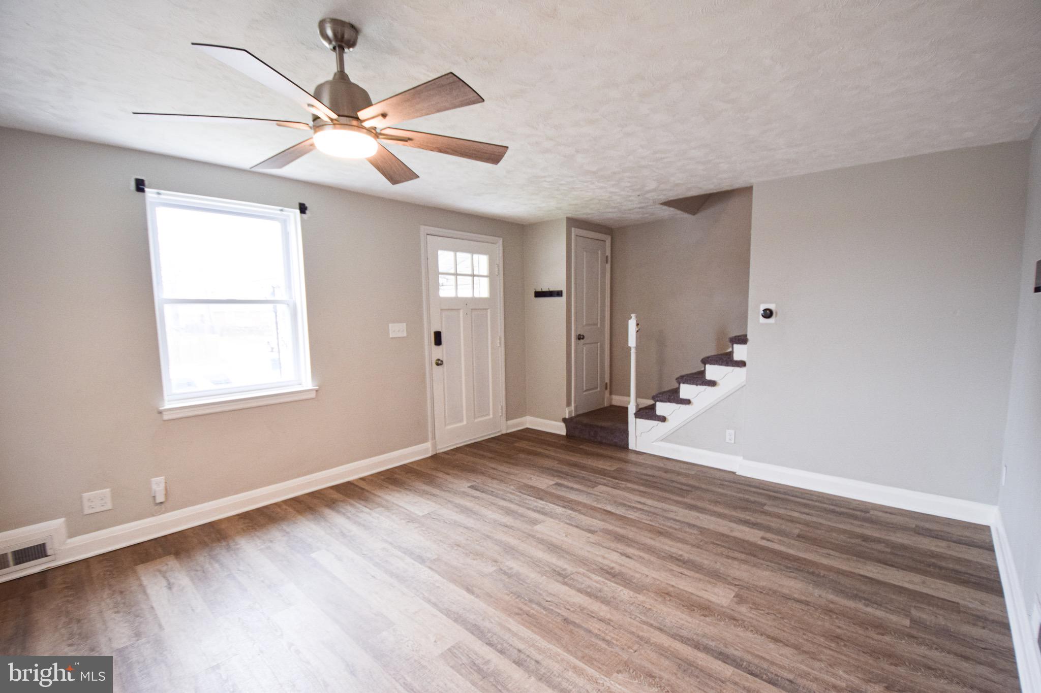 6419 Marietta Avenue Baltimore, MD 21214 - Photo 2 of 38 a view of an empty room with wooden floor and a window