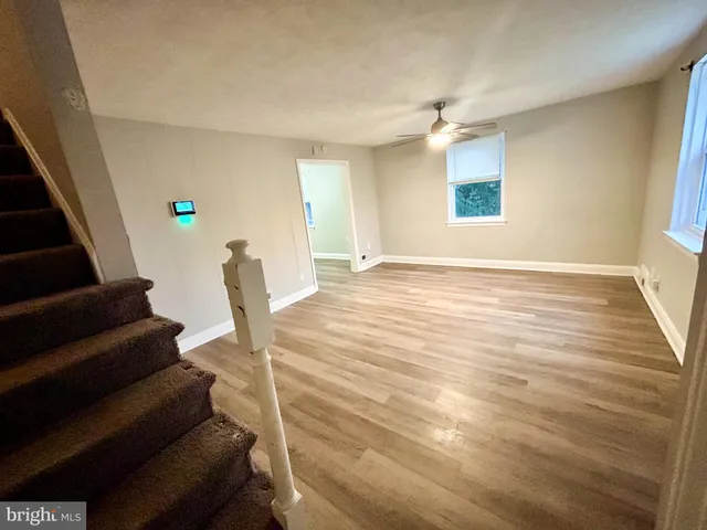 a view of an empty room with stairs and a window