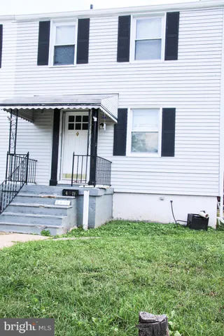a front view of a house with a yard with potted plants