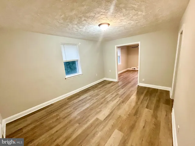 a view of a room with wooden floor and entryway