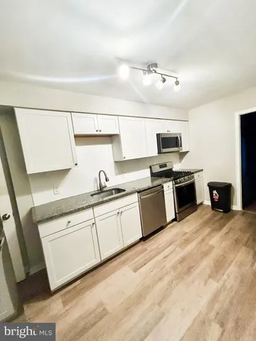 a kitchen with stainless steel appliances granite countertop a sink and a stove