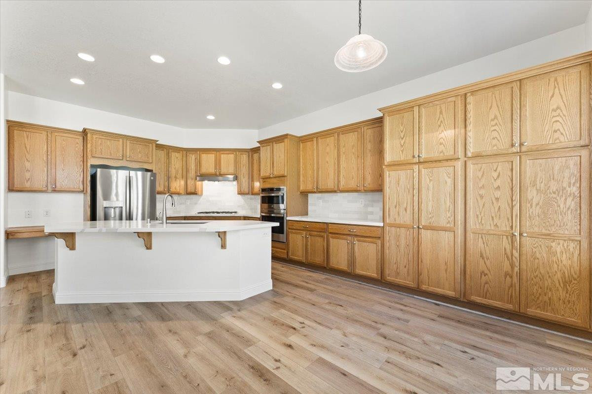 3259 Diamond Ridge Drive Reno, NV 89523 - Photo 12 of 40 a kitchen with stainless steel appliances granite countertop a refrigerator a sink dishwasher a stove and white countertops with wooden floor