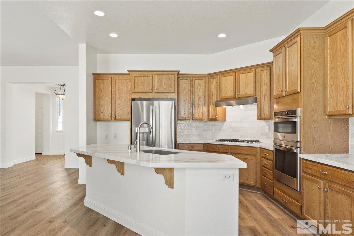 3259 Diamond Ridge Drive Reno, NV 89523 - Photo 13 of 40 a kitchen with stainless steel appliances granite countertop a refrigerator a stove and a sink with wooden floors