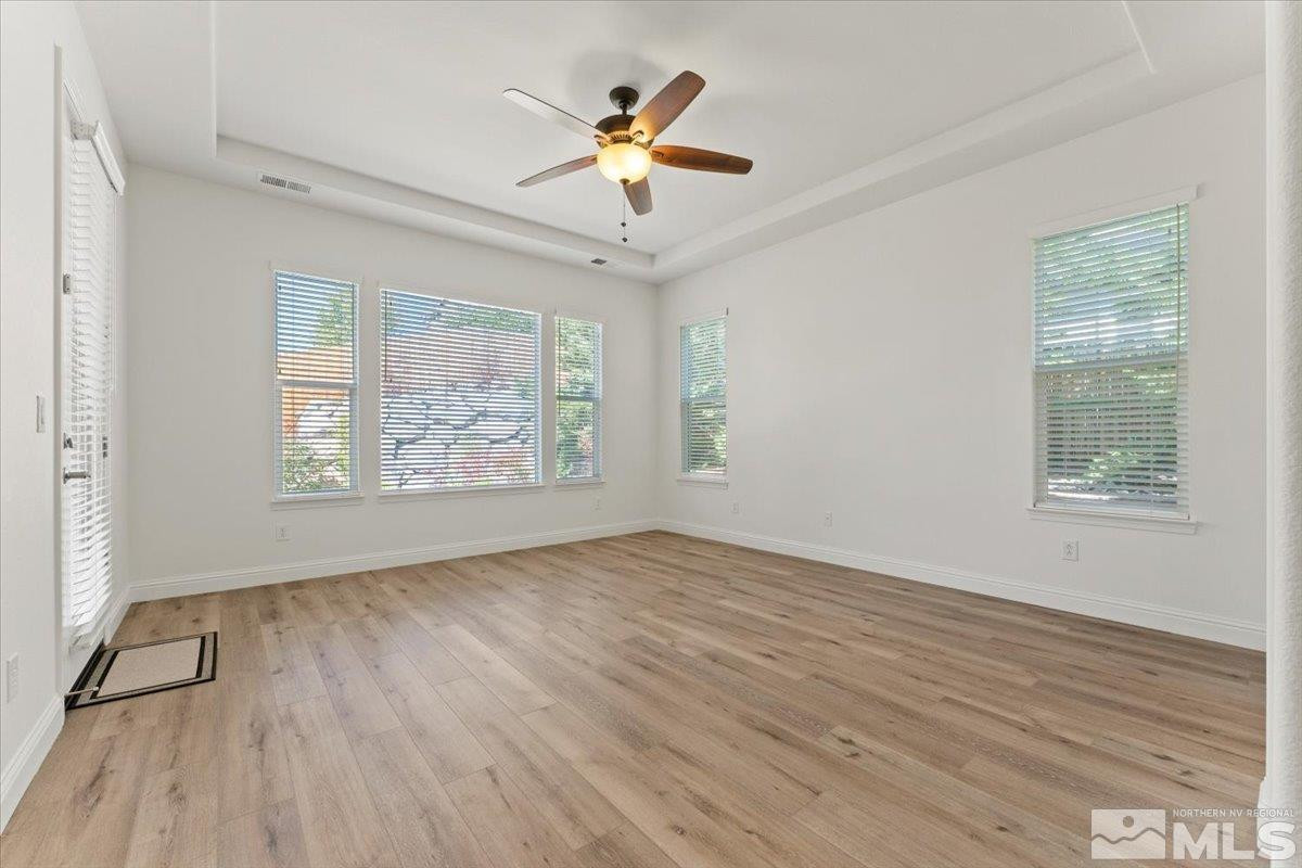 3259 Diamond Ridge Drive Reno, NV 89523 - Photo 16 of 40 an empty room with wooden floor chandelier fan and windows