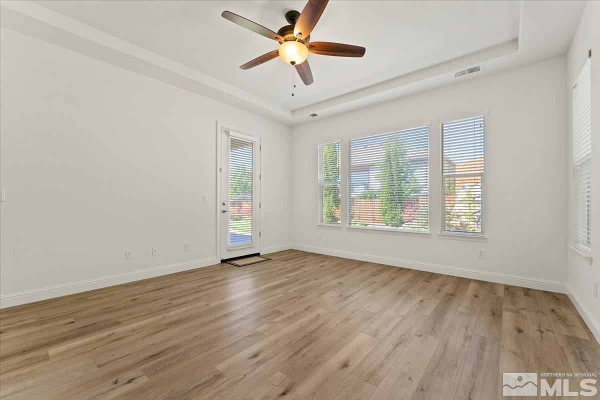 3259 Diamond Ridge Drive Reno, NV 89523 - Photo 17 of 40 an empty room with wooden floor chandelier fan and windows