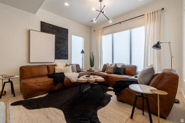 Recessed lighting and a contemporary chandelier illuminate the space