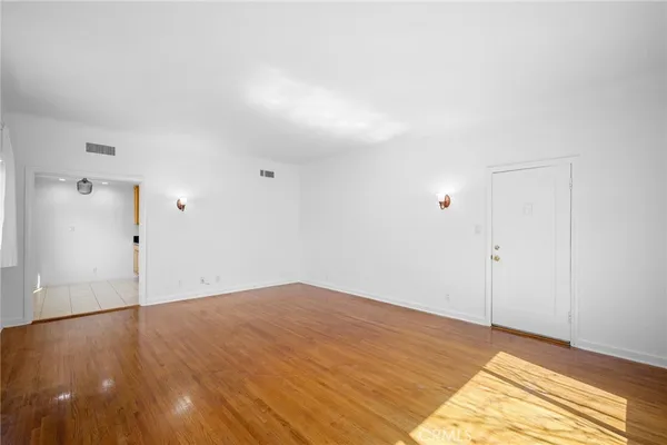 a view of empty room with wooden floor