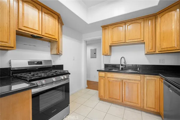 a kitchen with granite countertop a sink stainless steel appliances and cabinets