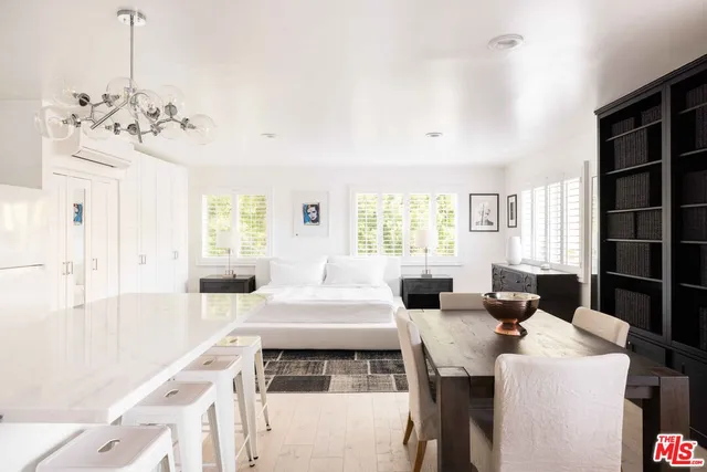 a living room with furniture a chandelier and a flat screen tv