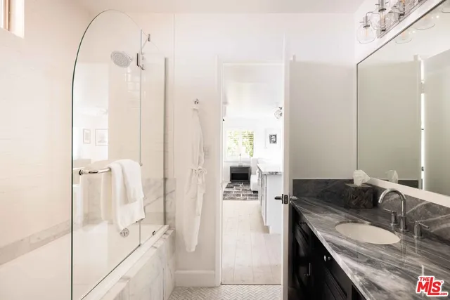 a bathroom with a granite countertop sink mirror and shower