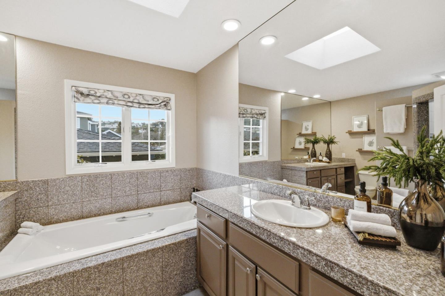 418 Ridge Road San Carlos, CA 94070 - Photo 26 of 64 a bathroom with a granite countertop tub a sink and a large mirror