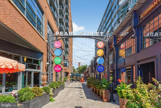 a street view with tall buildings and a flower garden