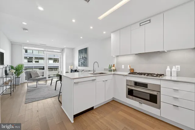 a kitchen with granite countertop white cabinets and white appliances