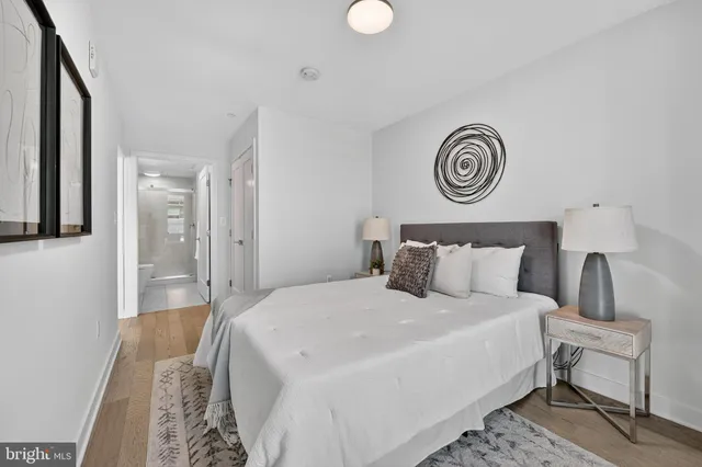 a bedroom with a bed and a lamp on dresser