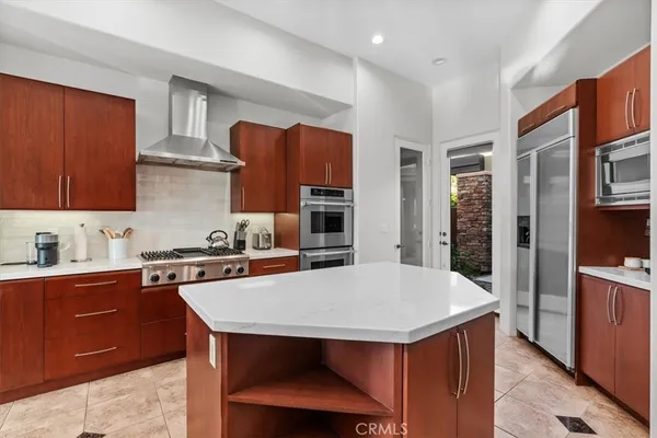 a kitchen with kitchen island granite countertop a stove a sink a dining table and chairs