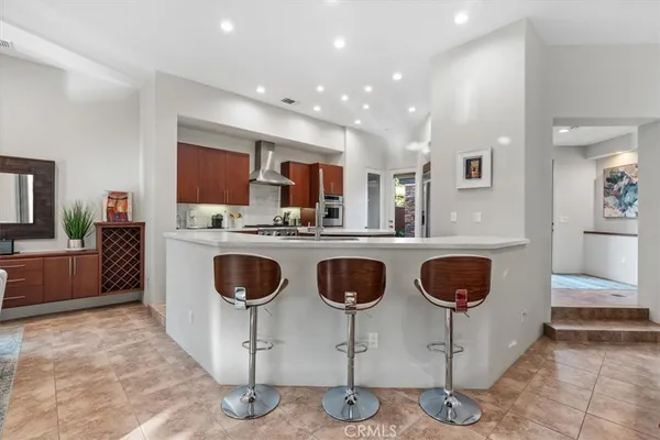 a dining hall with stainless steel appliances granite countertop a stove and a sink