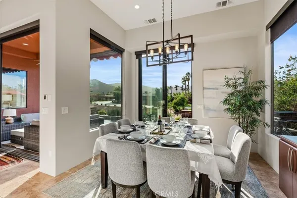 a view of a dining room with furniture large windows and wooden floor