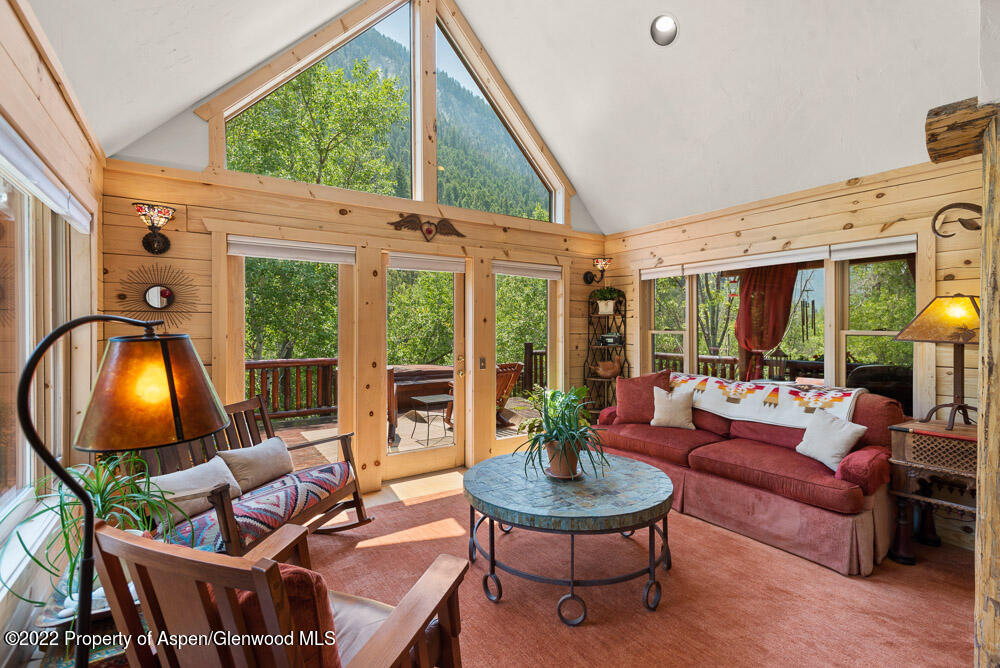 73 Juniper Court Marble, CO 81623 - Photo 21 of 47 a living room with furniture a fireplace and a floor to ceiling window