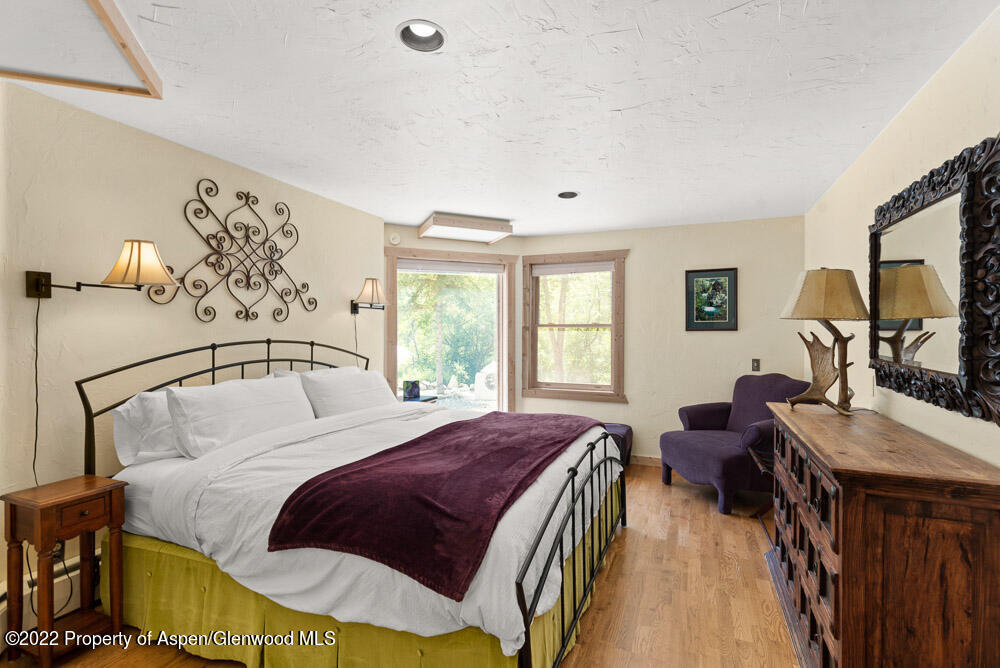 73 Juniper Court Marble, CO 81623 - Photo 30 of 47 a spacious bedroom with a bed a dresser next to a window
