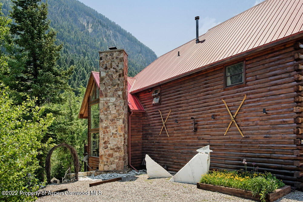 73 Juniper Court Marble, CO 81623 - Photo 3 of 47 a view of a brick house with a flower garden
