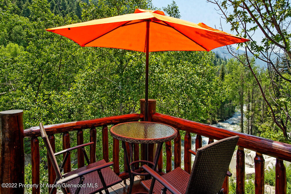 73 Juniper Court Marble, CO 81623 - Photo 6 of 47 a balcony with a table and chairs under an umbrella