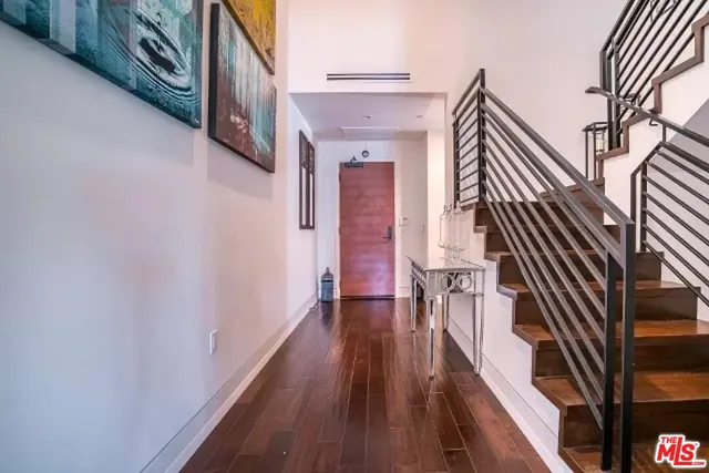 a view of a hallway with wooden floor and staircase