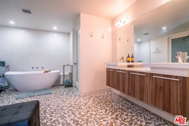 a bathroom with a bathtub sink and mirror