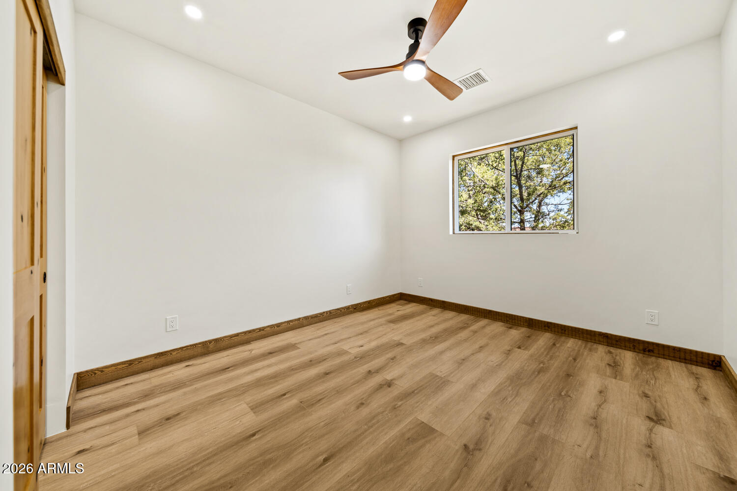 2235 Par Place Overgaard, AZ 85933 - Photo 23 of 42 a view of an empty room with wooden floor and a window