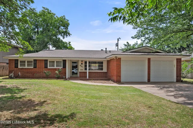 a front view of a house with a garden and trees