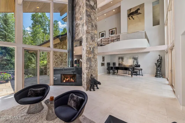 a living room with furniture a fireplace and a floor to ceiling window