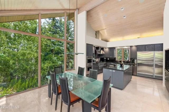 a kitchen with stainless steel appliances granite countertop a stove a sink and a dining table with granite countertop